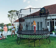 Bild in Galerie-Viewer laden, A young girl standing on an outdoor trampoline with her family watching her