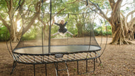 Charger l'image dans la visionneuse de galerie, A kid jumping on a springfree oval trampoline in a backyard