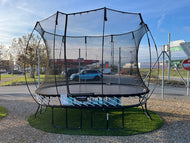 Load image into Gallery viewer, A medium-sized oval trampoline  displayed outdoors.
